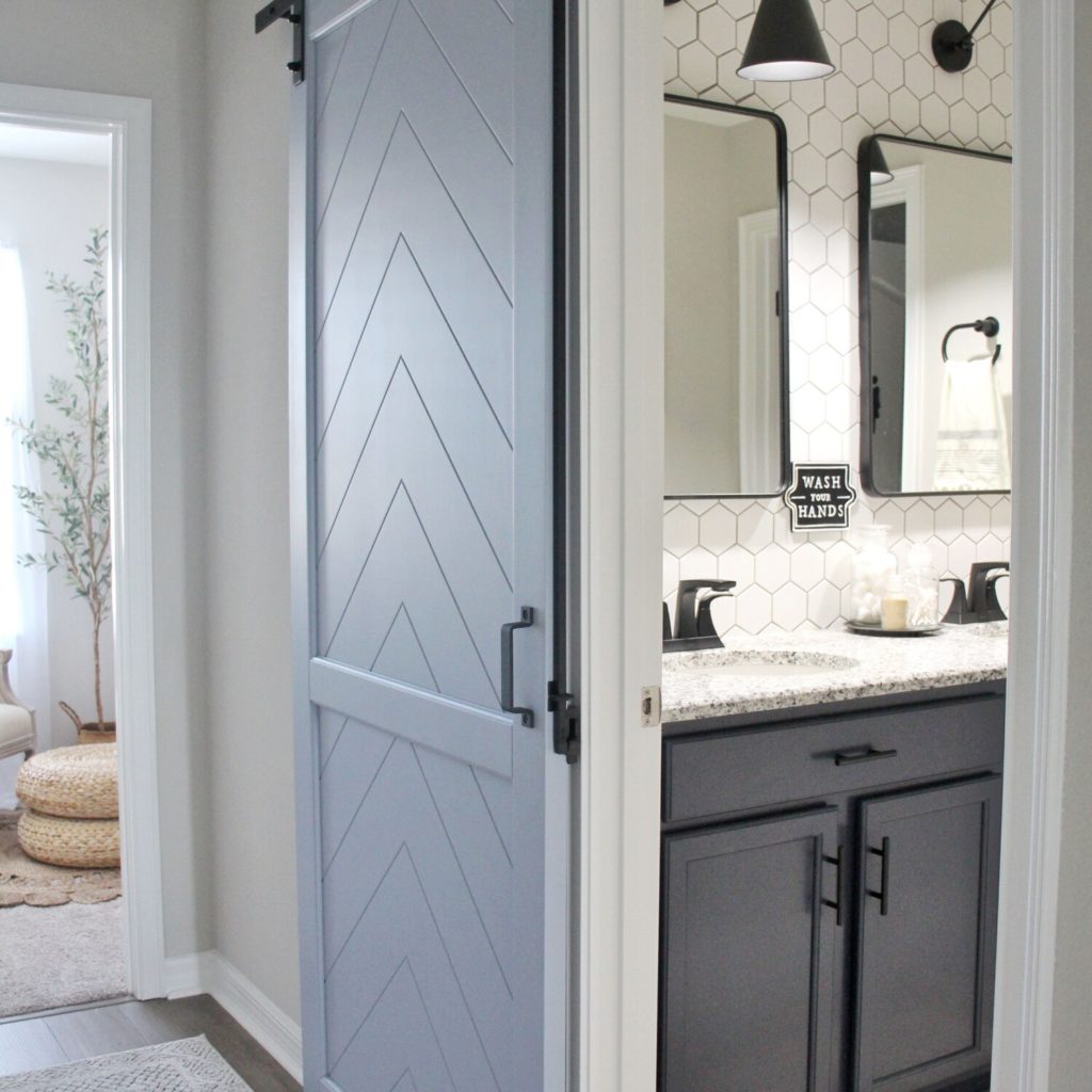 Modern concept washroom with sink and a sliding grey barn door.