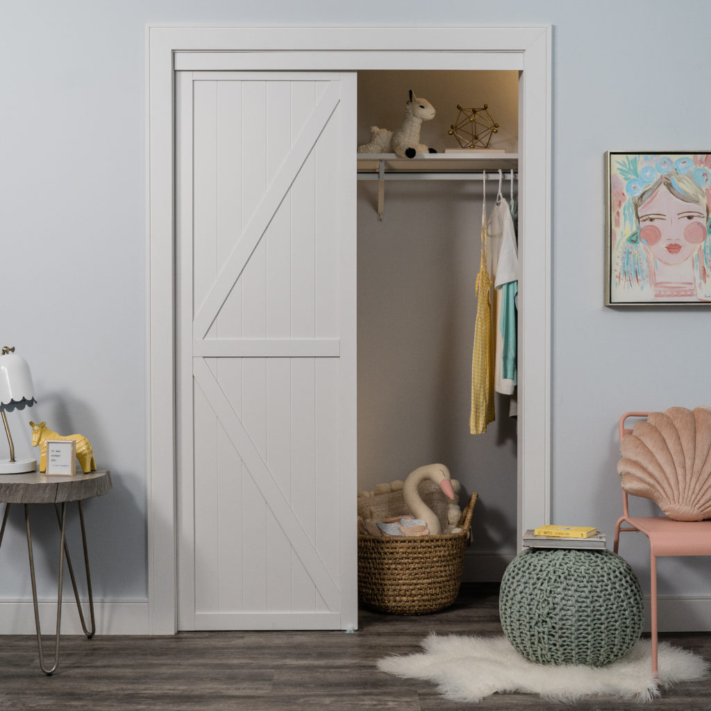 White K Design Bypass Closet Door in a childrens room with pastel toys in closet.